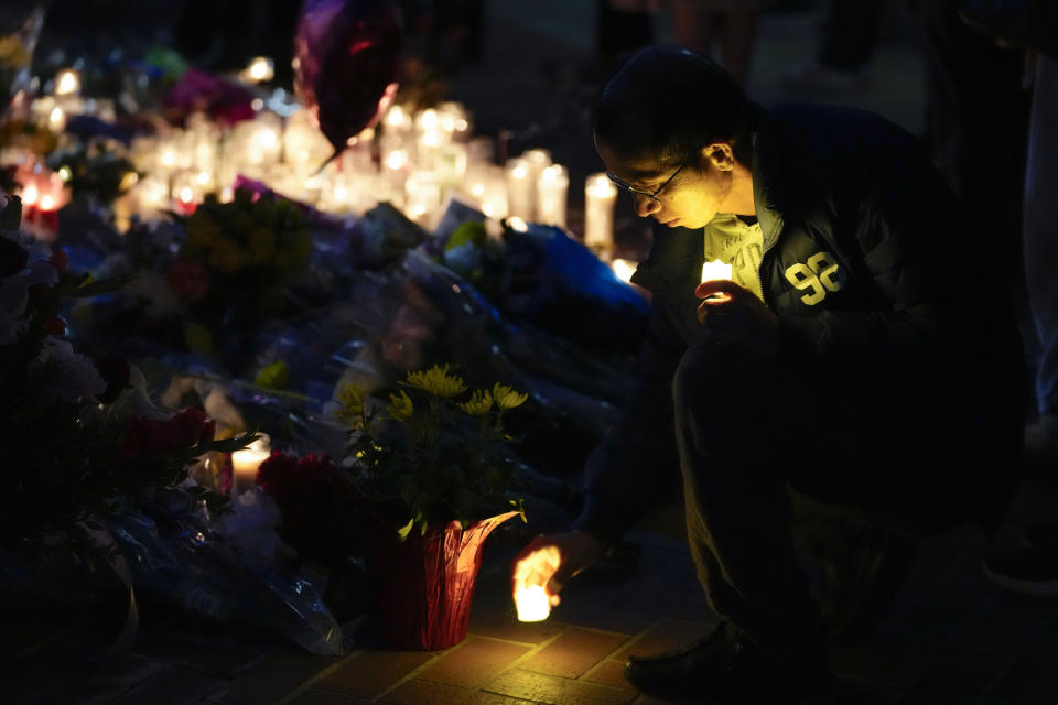 A man sets down a candle during a vigil outside Monterey Park City Hall, blocks from the Star Ballroom Dance Studio on Tuesday, Jan. 24, 2023, in Monterey Park, Calif. A gunman killed multiple people at the ballroom dance studio late Saturday amid Lunar New Years celebrations in the predominantly Asian American community. (AP Photo/Ashley Landis)