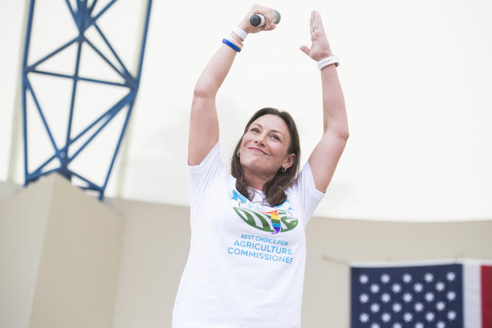 Nikki Fried holds a microphone aloft at a Jimmy Buffett concert 