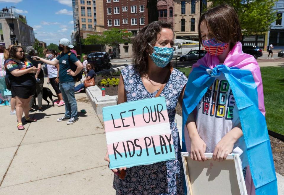 FILE - In this Wednesday, May 26, 2021 file photo, Maddy Niebauer and her 10-year-old transgender son, Julian, from Middleton, Wis., take part in a rally for transgender rights at the Capitol in Madison, Wis. Republicans who control the state Legislature are holding hearings Wednesday on legislation that would ban transgender athletes from competing in girls’ and women’s school sports — a proposal opposed by nearly 20 groups, including the statewide body that oversees high school sports. (Mark Hoffman/Milwaukee Journal-Sentinel via AP, File)=WIMIL