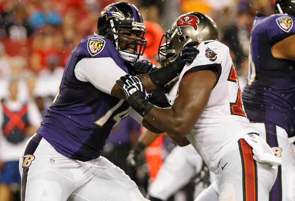 Ravens offensive tackle Michael Oher, left, blocks Buccaneers defensive end Lazarius Levingston during the second quarter at Raymond James Stadium in Tampa, Florida on Aug. 8, 2013.