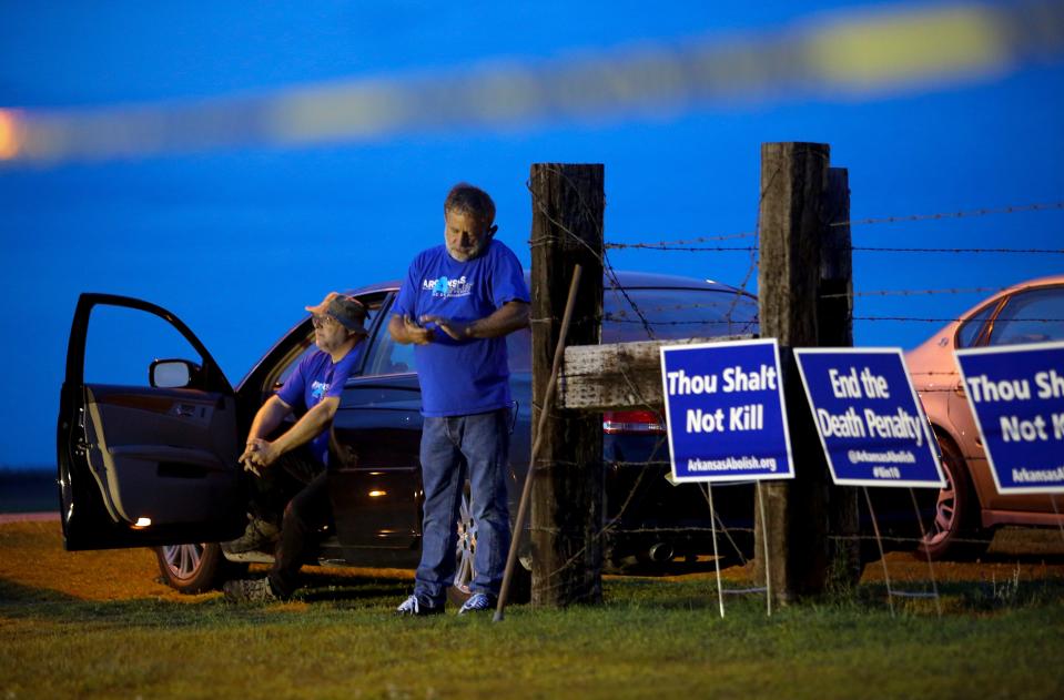 Anti-death penalty supporters Abraham Bonowitz, left, and Randy Gardner wait near their taped off "protest corral" outside the Varner Unit - Credit: AP