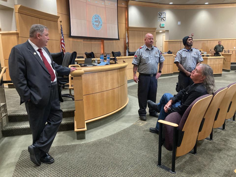 Shasta County CEO David Rickert, left, and two security guards wait for Christian Gardinier to leave the Shasta County Board of Supervisors chamber after it was cleared on Tuesday, Aug. 29, 2023. Gardinier was asked to leave after chair Patrick Jones said he disrupted the meeting.