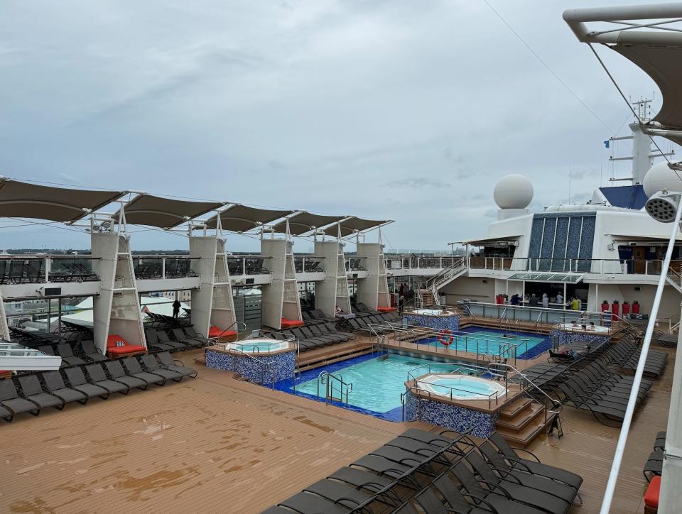 storm clouds over an empty pool deck of a cruise ship sailing in the Carribean