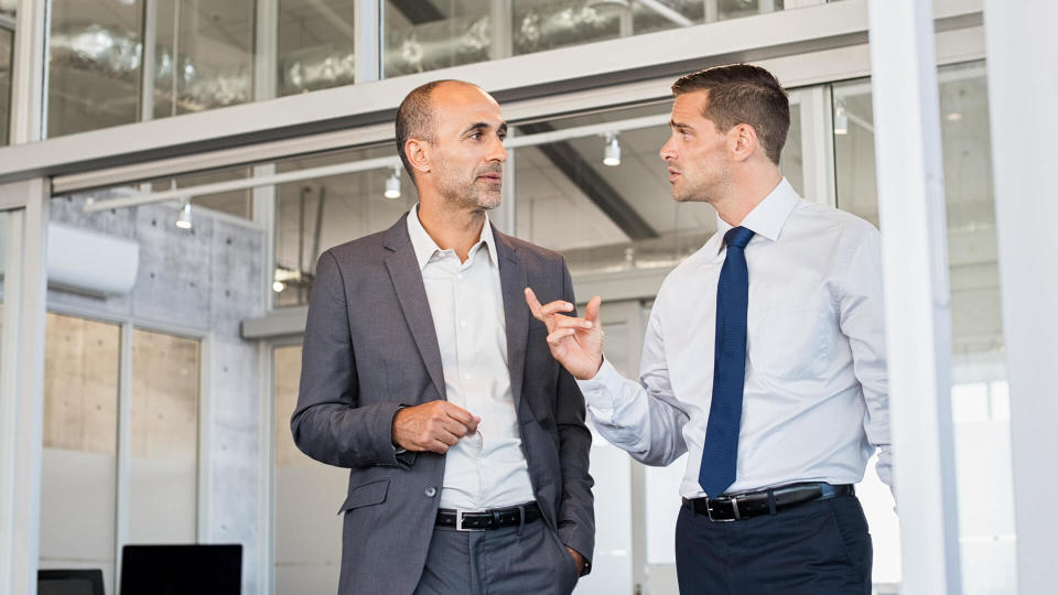 Two businessmen discussing project at meeting at office.