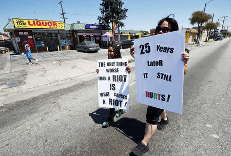 A mother and her daughter walk back to the intersection of Florence and Normandie Avenue, the flashpoint where the riots started 25 years ago, after participating in a march to remember and honor the victims of the 1992 Los Angeles riots in Los Angeles, California, U.S., April 29, 2017. REUTERS/Kevork Djansezian