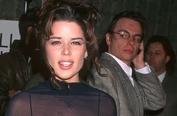 A man checking out Neve Campbell on the red carpet