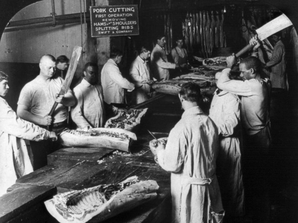 Workers cutting up hogs by hand at the Swift and Company meatpacking house in Chicago (Granger/Rex/Shutterstock)