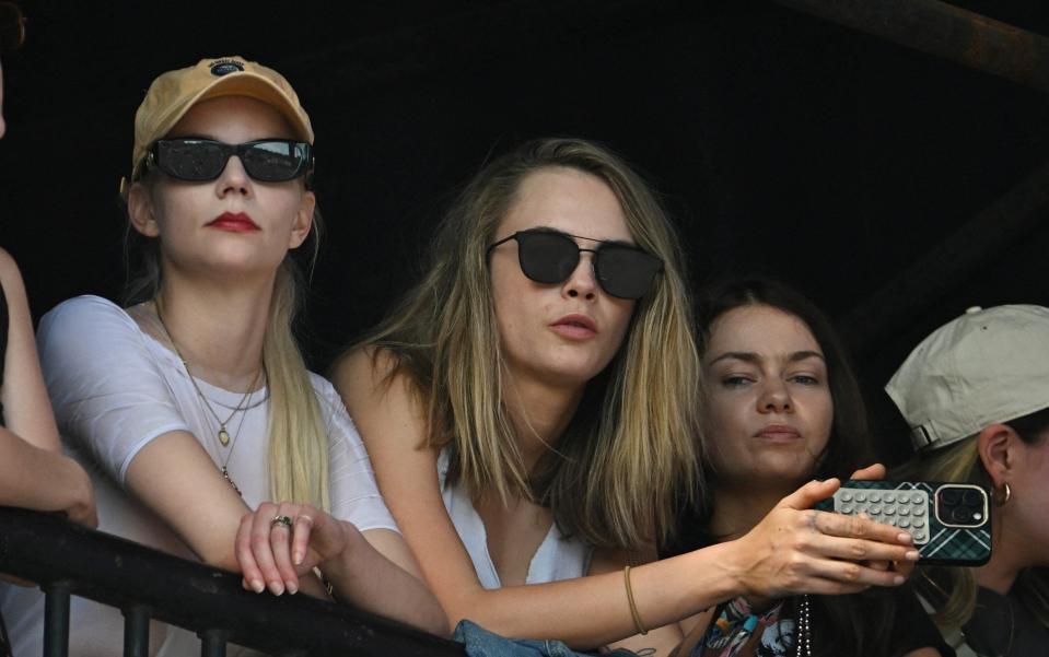 Anya Taylor-Joy and Cara Delevingne watch them perform