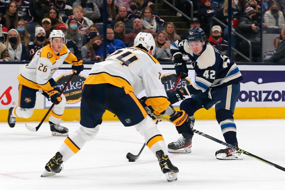 Dec 30, 2021; Columbus, Ohio, USA; Columbus Blue Jackets center Alexandre Texier (42) passes the puck as Nashville Predators right wing Matt Luff (24) defends during the second period at Nationwide Arena. Mandatory Credit: Russell LaBounty-USA TODAY Sports