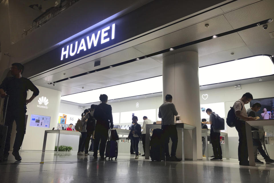 FILE - In this Nov. 15, 2019, file photo people look at a Huawei store in Shenzhen Bao'an International Airport in Shenzhen in southern China's Guangdong Province. A federal judge in Texas has dismissed Chinese tech giant Huawei's lawsuit challenging a U.S. law that bars the government and its contractors from using Huawei equipment because of security concerns. (AP Photo/Olivia Zhang, File)