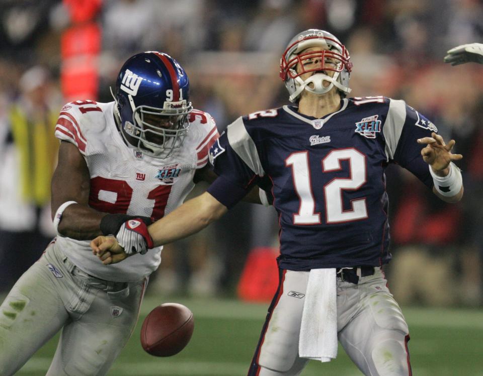 New York Giants defensive end Justin Tuck (91) strips the football from New England Patriots quarterback Tom Brady (12) in the second quarter of Sunday's Super Bowl XLII. Tuck played at Notre Dame. (AP Photo/Chris O'Meara)