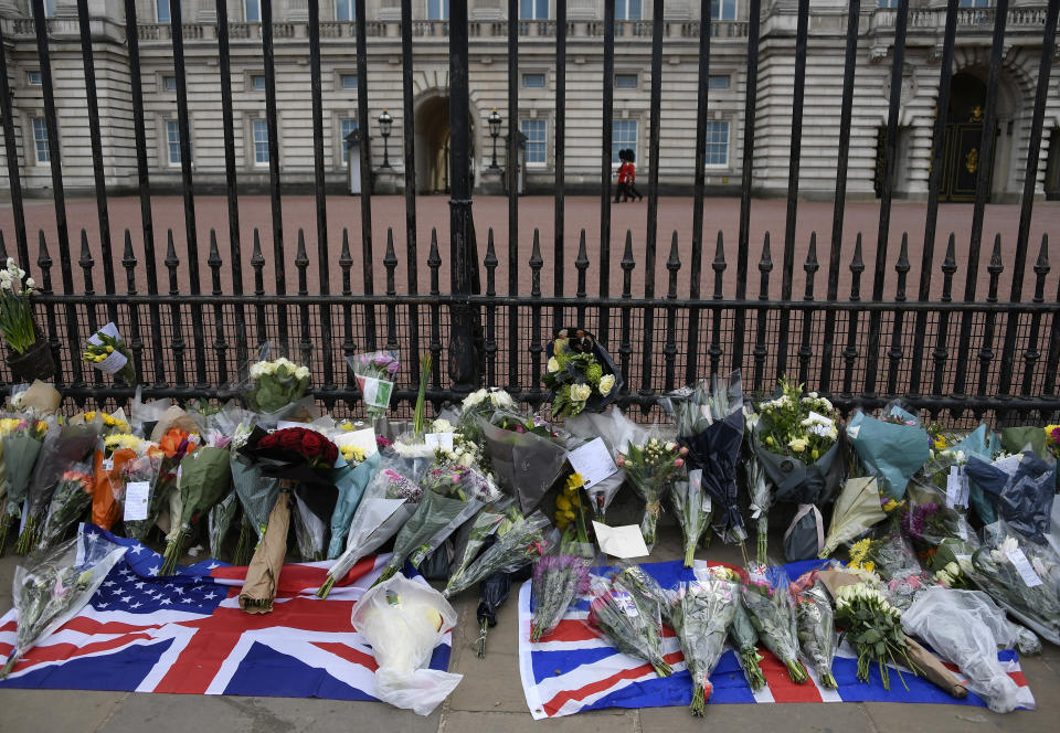 Flowers and other items are left by the public outside Buckingham Palace in London, Friday, April 9, 2021. Buckingham Palace officials say Prince Philip, the husband of Queen Elizabeth II, has died. He was 99. Philip spent a month in hospital earlier this year before being released on March 16 to return to Windsor Castle. (AP Photo/Alberto Pezzali)