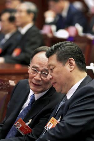 FILE PHOTO - China's President Xi Jinping (R) speaks to Wang Qishan, a member of the Standing Committee of the Political Bureau of the Communist Party of China (CPC) during the preparatory meeting of the annual session of China's parliament, the National People's Congress (NPC), at the Great Hall of the People in Beijing March 4, 2015. REUTERS/China Daily