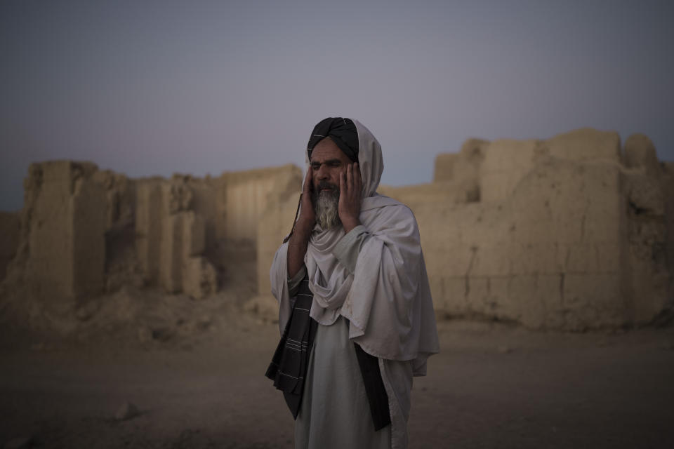 Mohammad Salim, the imam of Salar village, prays outside a mosque at dusk in Salar, Wardak province, Afghanistan, Tuesday, Oct. 12, 2021.In urban centers, public discontent toward the Taliban is focused on threats to personal freedoms, including the rights of women. In Salar, these barely resonate. The ideological gap between the Taliban leadership and the rural conservative community is not wide. Many villagers supported the insurgency and celebrated the Aug. 15 fall of Kabul which consolidated Taliban control across the country. (AP Photo/Felipe Dana)