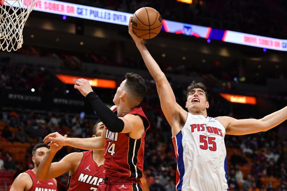 Detroit Pistons center Luka Garza (55) grabs a rebound over Miami Heat guard Tyler Herro (14) during the first half of an NBA basketball game, Thursday, Dec. 23, 2021, in Miami.