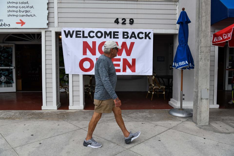 A sign reading "Welcome Back, Now Open" on Fort Lauderdale Beach Boulevard in Florida.