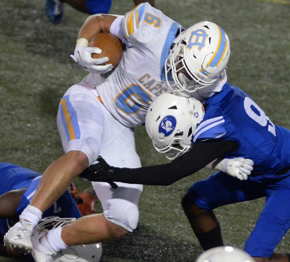 Brenn Scott of Cape Henlopen trying to power his way past Dover's Christopher Grady.