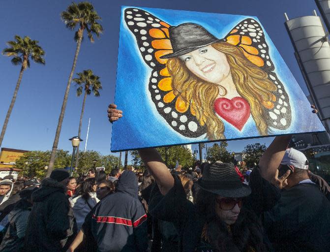 Fans mourn Jenni Rivera at a memorial televised a on giant television in Universal City in Los Angeles Wednesday, Dec. 19, 2012. The 43-year-old Rivera and six others died Dec. 9 in a crash that remained under investigation. Rivera sold more than 15 million copies of her 12 major-label albums. Her soulful singing style and honesty about her tumultuous personal life won her fans on both sides of the U.S.-Mexico border. She was also an actress and reality-TV star. (AP Photo/Damian Dovarganes