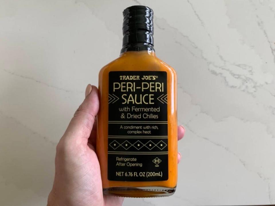 A bottle of Trader Joe's peri-peri sauce on a marble countertop.