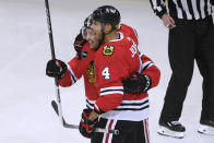 Chicago Blackhawks' Seth Jones (4) celebrates with Philipp Kurashev (23) after scoring a goal against the Calgary Flames during the first period of an NHL hockey game Tuesday, March 26, 2024, in Chicago. (AP Photo/Paul Beaty)