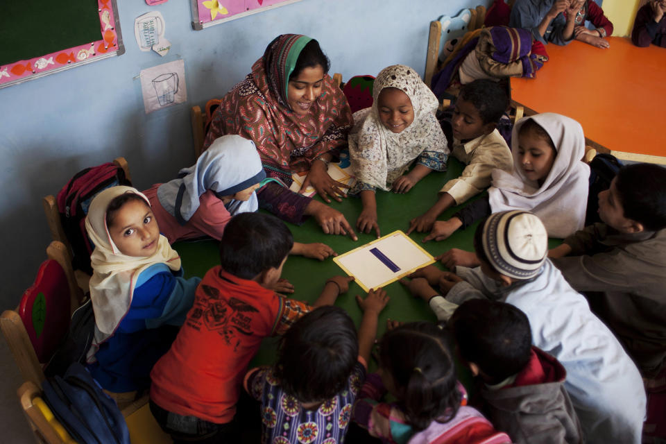 <p>Pakistani students gather around Humaira Bachal, the founder of a charity school as she teaches them in a classroom in Karachi, Pakistan, Feb. 24, 2014. (AP Photo/Shakil Adil) </p>