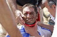 FDJ rider William Bonnet of France receives medical help as he sits on the ground after a fall during the 159,5 km (99 miles) third stage of the 102nd Tour de France cycling race from Anvers to Huy, Belgium, July 6, 2015. REUTERS/Eric Gaillard