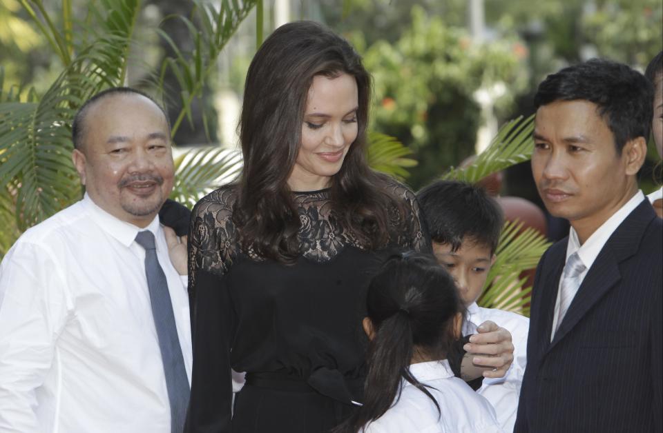 Hollywood actress Angelina Jolie, center, stands together with Cambodian film maker Rithy Panh, left, as they wait for the start a press conference in Siem Reap province, Cambodia, Saturday, Feb. 18, 2017. Jolie on Saturday launches her two-day film screening of "First They Killed My Father" is presiding over by King Sihamoni, in Angkor complex in Siem Reap province. (AP Photo/Heng Sinith)