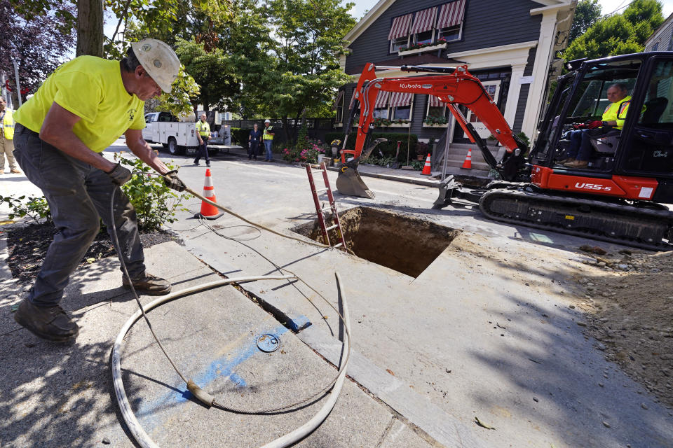 Richie Nero, left, of Boyle & Fogarty Construction, works on removing a old lead residential water supply line, outside a home where service was getting upgraded to copper, Thursday, June 29, 2023, in Providence, R.I. Health and environmental groups have been fighting for lead-free water to drink in Providence for at least a decade. (AP Photo/Charles Krupa)