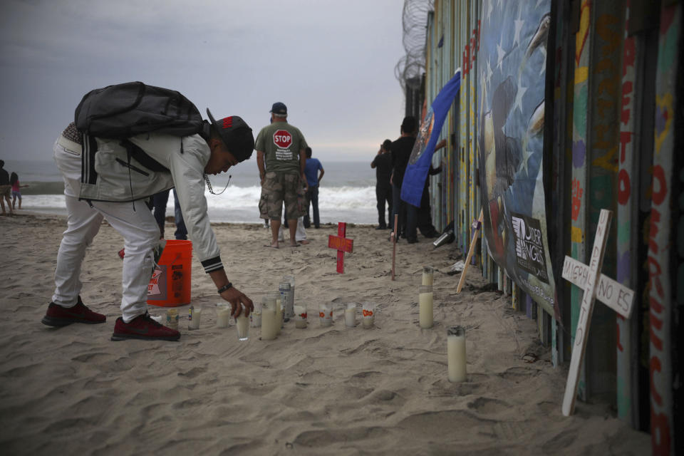 Candles are placed next to the border fence that separates Mexico from the United States, in memory of migrants who have died during their journey toward the U.S., in Tijuana, Mexico, late Saturday, June 29, 2019. (AP Photo/Emilio Espejel)