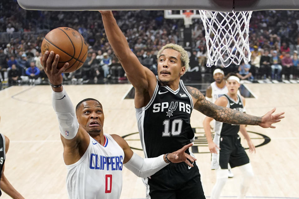 Los Angeles Clippers guard Russell Westbrook, left, shoots as San Antonio Spurs forward Jeremy Sochan defends during the first half of an NBA basketball game Sunday, Oct. 29, 2023, in Los Angeles. (AP Photo/Mark J. Terrill)