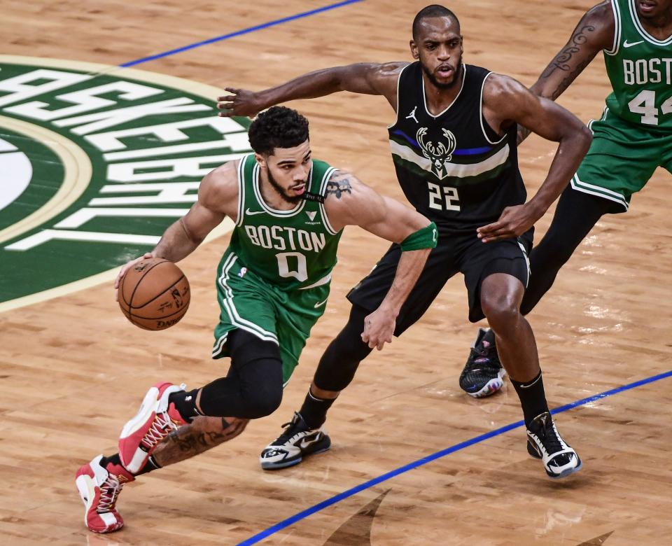 Celtics forward Jayson Tatum drives past Bucks forward Khris Middleton.