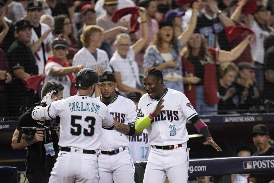 Arizona Diamondbacks' Christian Walker (53) celebrates his home run with teammates Geraldo Perdomo (2) and Ketel Marte, center, during the third inning in Game 3 of a baseball NL Division Series against the Los Angeles Dodgers, Wednesday, Oct. 11, 2023, in Phoenix. (AP Photo/Ross D. Franklin)