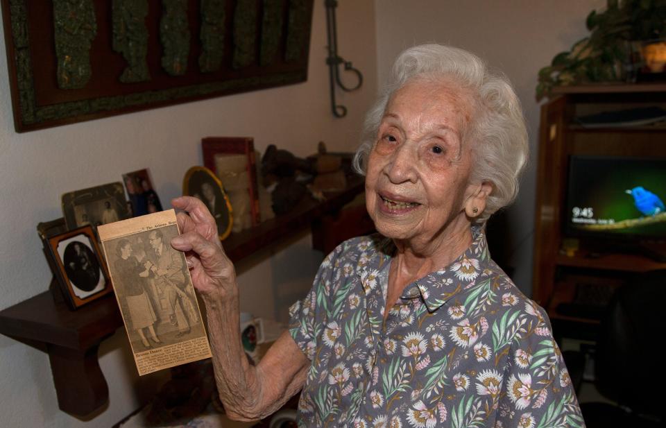 Marguerite Trujillo holds a vintage picture printed in the Arizona Republic of her performing a broom dance at a charity ball with former Phoenix mayor John Udall at her home in Phoenix on June 30.