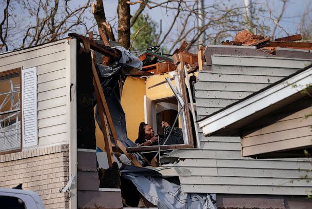 PHOTO: A woman collects belongings from a family members home after the roof was ripped off from a tornado on Oakview Drive in North Little Rock, Ark., on March 31, 2023. (Thomas Metthe/Arkansas Democrat-Gazette via AP)