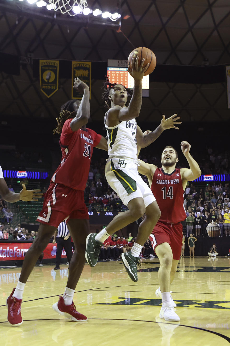 Baylor guard Dantwan Grimes, center, goes up to score between Gardner-Webb forward Isaiah Richards (24) and guard Shahar Lazar (14) in the second half of an NCAA college basketball game, Sunday, Nov. 12, 2023, in Waco, Texas. (AP Photo/Jerry Larson)