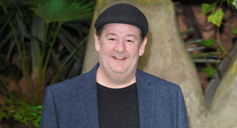 Comedian Johnny Vegas wears a blue blazer and a black cap. (Getty Images)