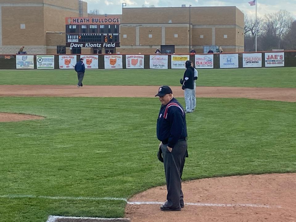 Umpire John Whitson stands near home plate in Heath for a baseball game between the Bulldogs and Delaware Hayes Pacers. Whitson will be inducted into the OHSAA Hall of Fame after 50 years of officiating.