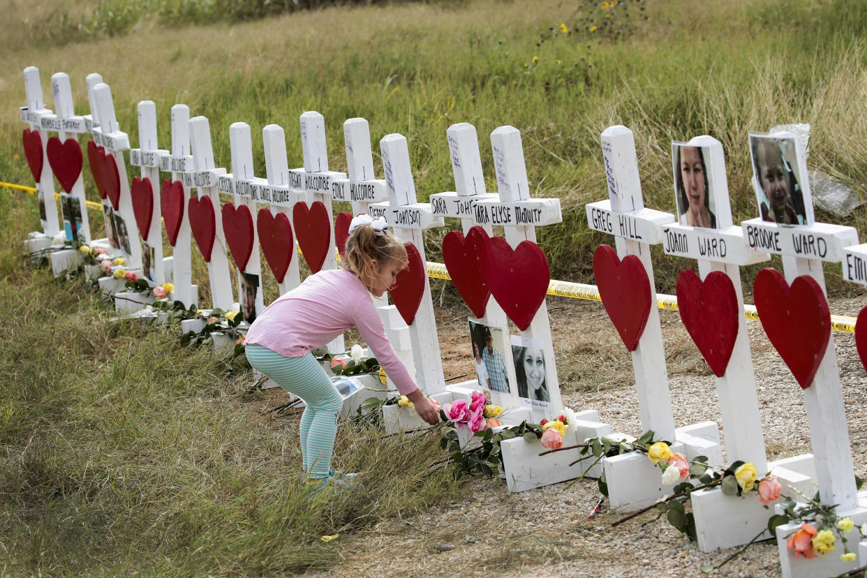 Image: Four-year-old Shaelyn Gisler leaves a flower at a memorial where 26 crosses were placed to honor the victims killed at the First Baptist Church of Sutherland Springs on November 9, 2017 in Sutherland Springs, Texas. (Scott Olson / Getty Images file)