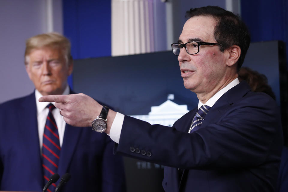 President Donald Trump listens as Treasury Secretary Steven Mnuchin speaks about the coronavirus in the James Brady Press Briefing Room of the White House, Thursday, April 2, 2020, in Washington. (AP Photo/Alex Brandon)