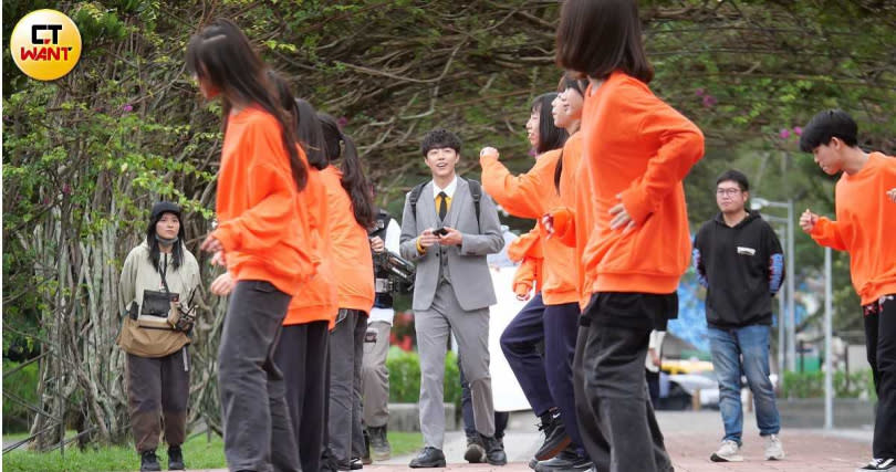 看著穿著橘色服裝的眾人在跳舞，蔡凡熙露出憨笑。（圖／本刊攝影組）