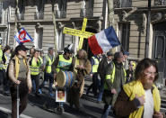 Yellow vest protesters march during a protest in Paris, Sunday, Feb. 17, 2019. French yellow vest protesters are marking three months since the kickoff of their anti-government movement, as anti-Semitic remarks by some demonstrators have raised national concern about the movement's ascendant radical fringe. (AP Photo/Thibault Camus)