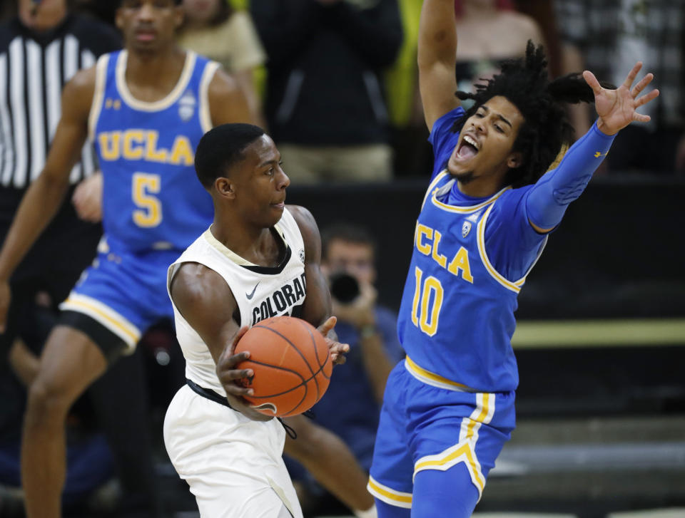 Colorado guard McKinley Wright IV, left, passes the ball as UCLA guard Tyger Campbell defends in the first half of an NCAA college basketball game Saturday, Feb. 22, 2020, in Boulder, Colo. (AP Photo/David Zalubowski)