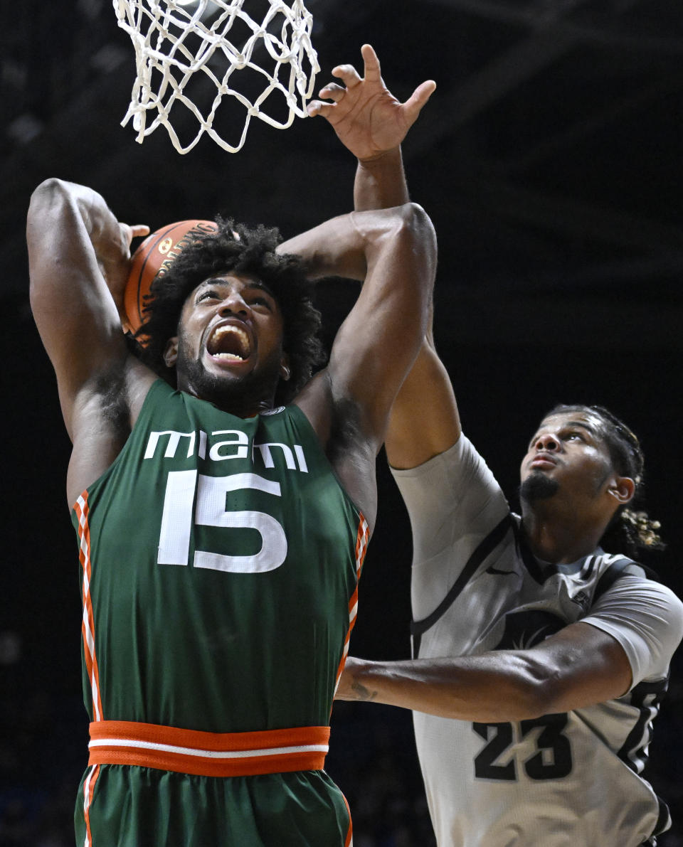 Providence forward Bryce Hopkins (23) fouls Miami forward Norchad Omier (15) as he goes up for a dunk in the second half of an NCAA college basketball game, Saturday, Nov. 19, 2022, in Uncasville, Conn. (AP Photo/Jessica Hill)