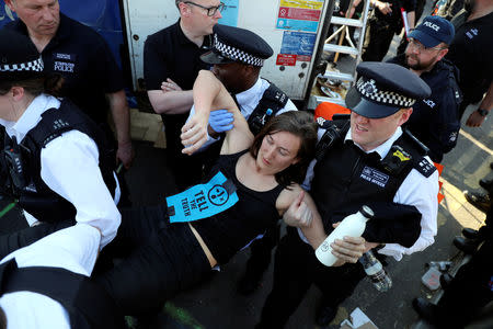 A climate change activist is detained during the Extinction Rebellion protest on Waterloo Bridge in London, Britain April 20, 2019. REUTERS/Simon Dawson