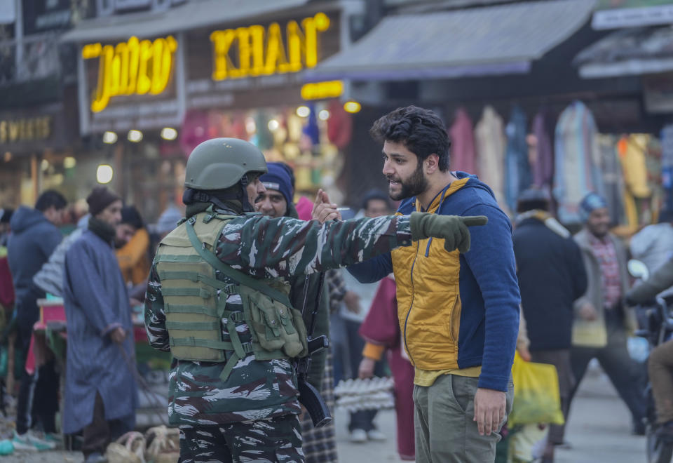 A man talks to an Indian paramilitary soldier standing guard in Srinagar, Indian controlled Kashmir,Tuesday, Dec 23, 2023. Anger spread in some remote parts of Indian-controlled Kashmir after three civilians were killed while in army custody, officials and residents said Saturday. This comes two days after a militant ambush killed four soldiers. (AP Photo/Mukhtar Khan)