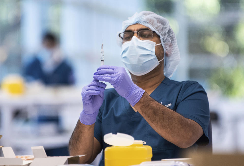 A technician prepares a Pfizer vaccine in the pharmacy area of the newly opened COVID-19 Vaccination Centre in Sydney, Australia, Monday, May 10, 2021. (James Gourley/Pool Photo via AP)