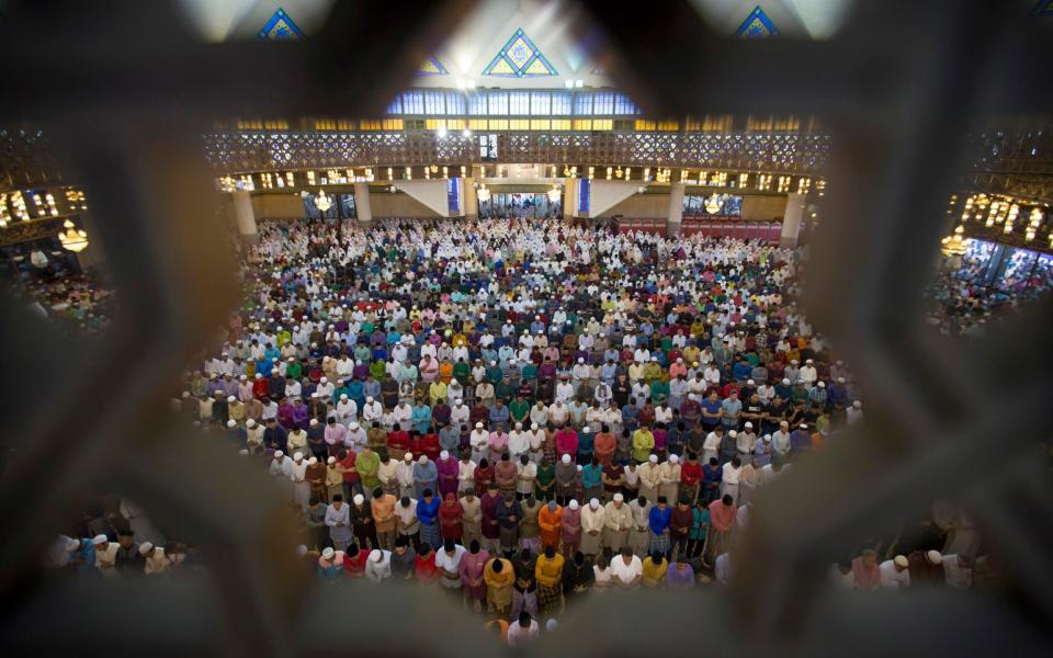 Muslims offer prayers during the first day of Eid al-Fitr, which marks the end of the holy fasting month of Ramadan in Kuala Lumpur, Malaysia - Vincent Thian/AP