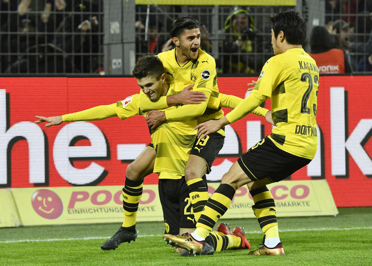 Borussia Dortmund’s Christian Pulisic is mobbed by teammates after scoring the winner against Hoffenheim. (AP Photo/Martin Meissner)