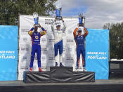 Alex Palou, al centro, celebra su tercer triunfo de la temporada de IndyCar, el domingo 12 de septiembre de 2021, en el Portland International Raceway de Portland, Oregon (AP Foto/Jenna Fryer)