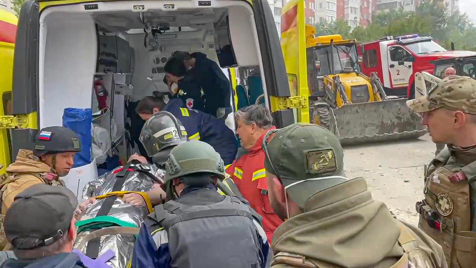 In this photo taken from video released by Belgorod regional governor Vyacheslav Gladkov's Telegram channel on Sunday, May 12, 2024, volunteers and paramedics transport a wounded person into an ambulance a partially collapsed block of flats authorities said was hit during an attack by Ukrainian shelling, in Belgorod, Russia. In a statement, Russia's Investigative Committee, the country's top law enforcement agency, said that the 10-story block had been hit by Ukrainian shelling. (Belgorod Region Governor Vyacheslav Gladkov Telegram channel via AP)